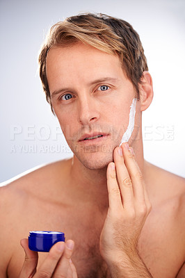 Buy stock photo Man, portrait and skincare cream or product for moisturiser routine or dermatology, transformation or studio. Male person, face and wellness as hygiene lotion for facial, white background or mockup