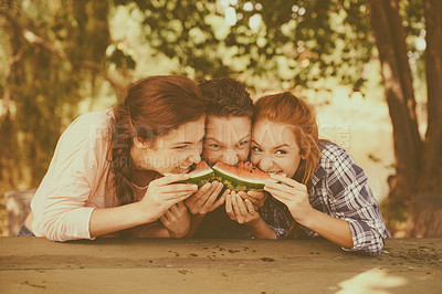 Buy stock photo Summer, friends and share watermelon for eating in park, crazy and group together for fun picnic. Gen z, people and bite fruit for hunger or nutrition, health and outdoor for bonding in sunshine