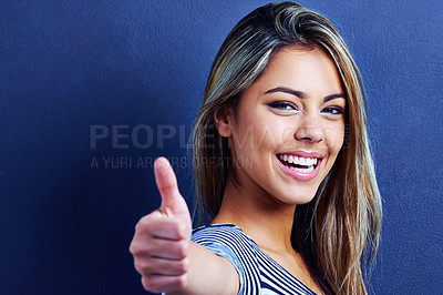 Buy stock photo Studio, portrait and woman with smile, thumbs up and excited or happiness on face of female person. Blue background, hands and deal for fashion, aesthetic and cool with clothes of girl with joy