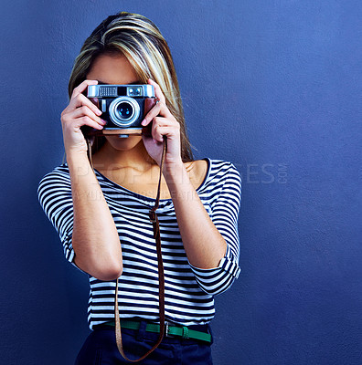 Buy stock photo Woman, photographer and camera by face in studio for creativity, media and journalist job by blue background. Girl, retro lens and photography with photoshoot for magazine, collection and newspaper