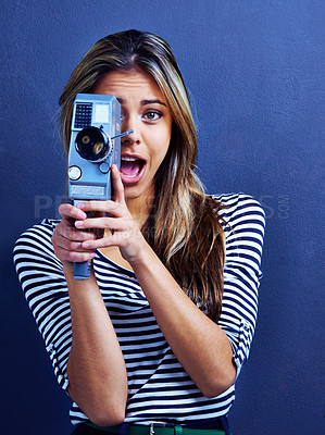 Buy stock photo Woman, smile and retro video camera in studio for recording, film or art in portrait by blue background. Girl, person or filmmaker with creativity, excited and shooting movie with vintage equipment