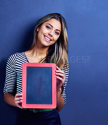 Buy stock photo Cropped shot of a happy young woman holding a chalkboard