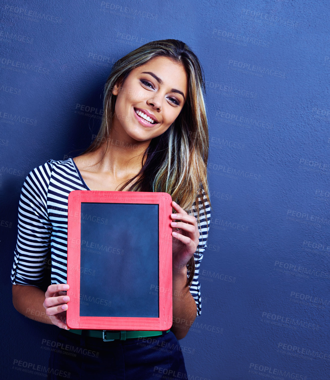 Buy stock photo Cropped shot of a happy young woman holding a chalkboard