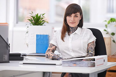 Buy stock photo A shot of a tattooed businesswoman sitting at her desk in her office