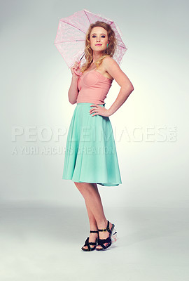 Buy stock photo Full length shot of a cute blonde girl posing with a parasol against a gray background