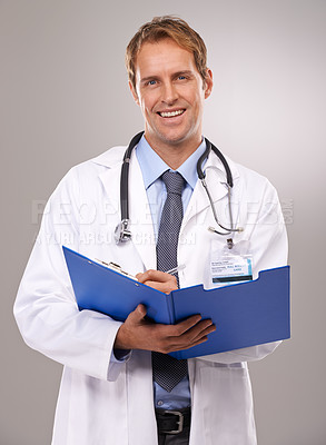 Buy stock photo Portrait of a smiling doctor writing in a patient's chart