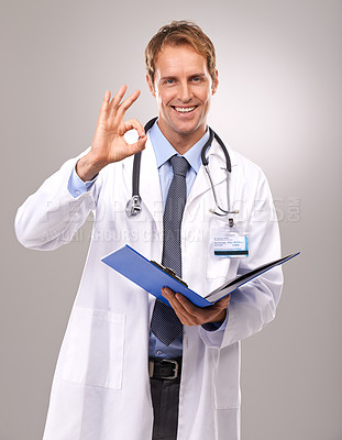Buy stock photo Clipboard, okay sign and portrait of doctor in studio for medical review, documents and report. Healthcare, hospital and man with hand gesture for success, good news and consulting on gray background