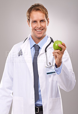 Buy stock photo Man, doctor and apple in studio portrait, medical expert and dietician on gray background. Happy male person, fruit and proud of choice or decision for nutrition, vitamins and minerals for health