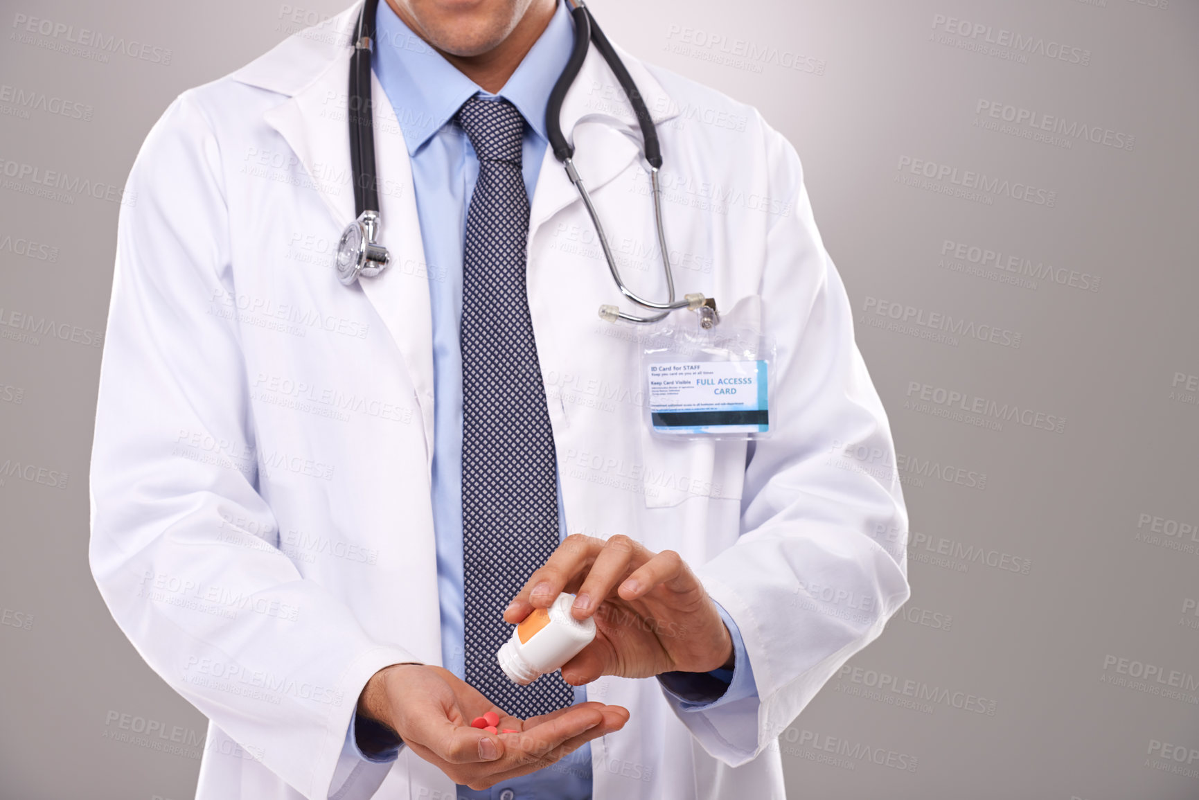Buy stock photo Cropped shot of a doctor emptying a bottle of pills into his hand