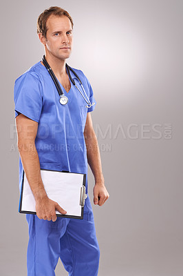 Buy stock photo Studio portrait of a handsome male surgeon holding a clipboard