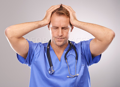 Buy stock photo Studio shot of a stressed doctor standing with his hands on his head