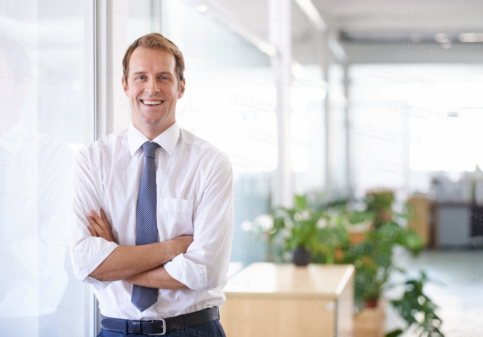 Buy stock photo Portrait of a handsome businessman leaning against a glass wall