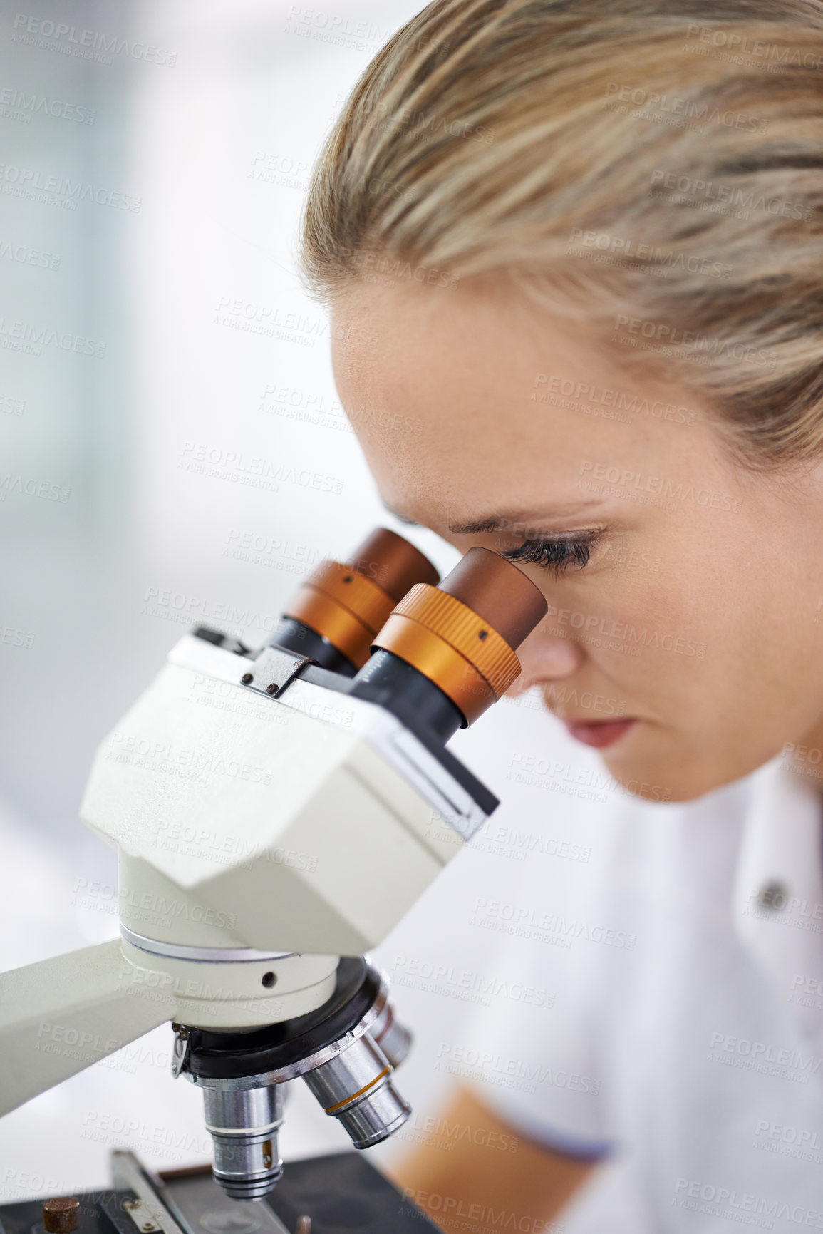 Buy stock photo Shot of a beautiful woman in a laboratory working with a microscope