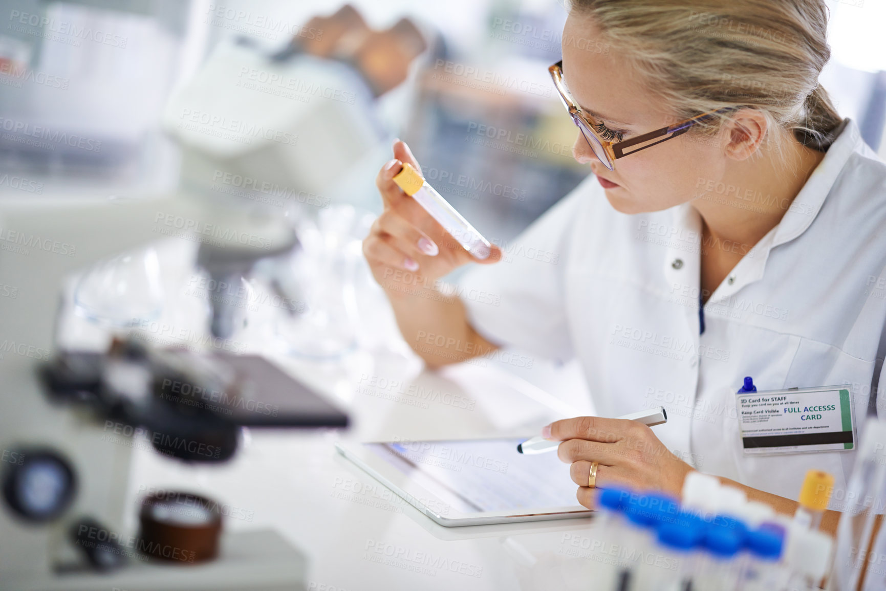 Buy stock photo A young scientist recording her findings on a tablet