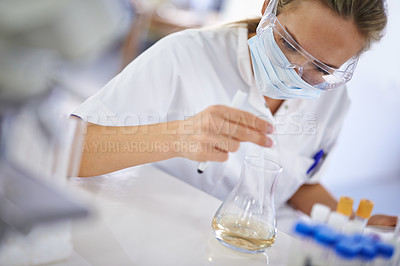 Buy stock photo A young scientist conducting an experiment in her lab