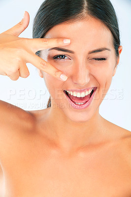 Buy stock photo Peace hands, skincare and portrait of happy woman with wink in studio for wellness on white background. V, eyes and female model smile for dermatology, shine or natural cosmetic, treatment or results