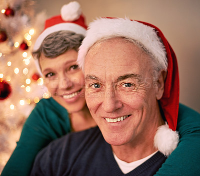 Buy stock photo Christmas, portrait and happy senior couple with love, care and support together in a home on holiday. Tree, retirement and marriage with a smile and hug in a house with celebration and santa hat