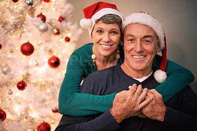 Buy stock photo Christmas, portrait and senior couple with love, care and support together in a home on holiday. Tree, retirement and marriage with a smile and hug in a house with celebration and santa hat with joy