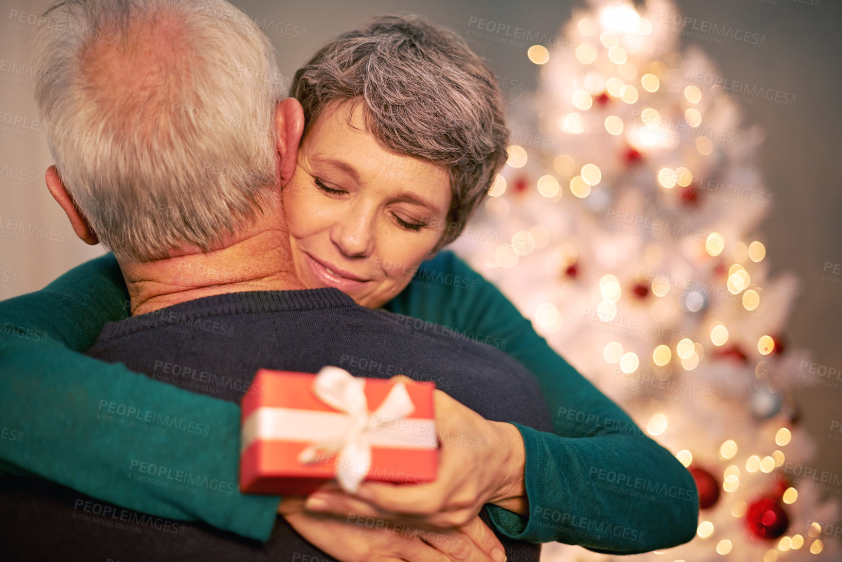 Buy stock photo Cropped shot of a happy mature couple embracing after exchanging Christmas gifts