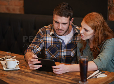 Buy stock photo Couple, browsing and checking menu with tablet for dinner date, streaming or review at indoor restaurant. Young man and woman chilling or relax with technology for social media at cafe or coffee shop