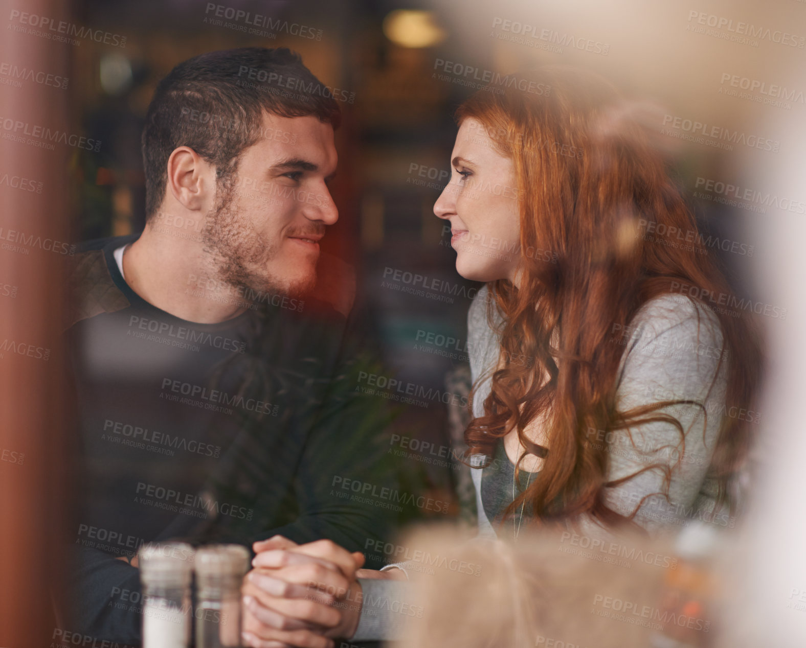 Buy stock photo Couple, happiness and holding hands on date at restaurant for bonding, romance and healthy relationship with relax. Man, woman and lens flare at cafe with smile, trust or love on anniversary vacation