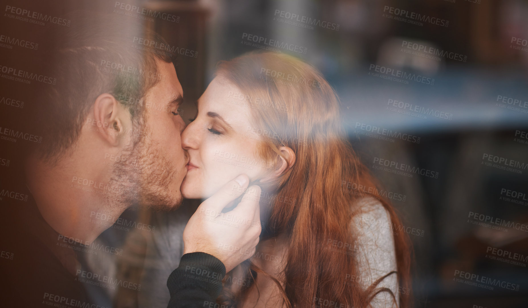 Buy stock photo A young couple sharing a kiss while on a date