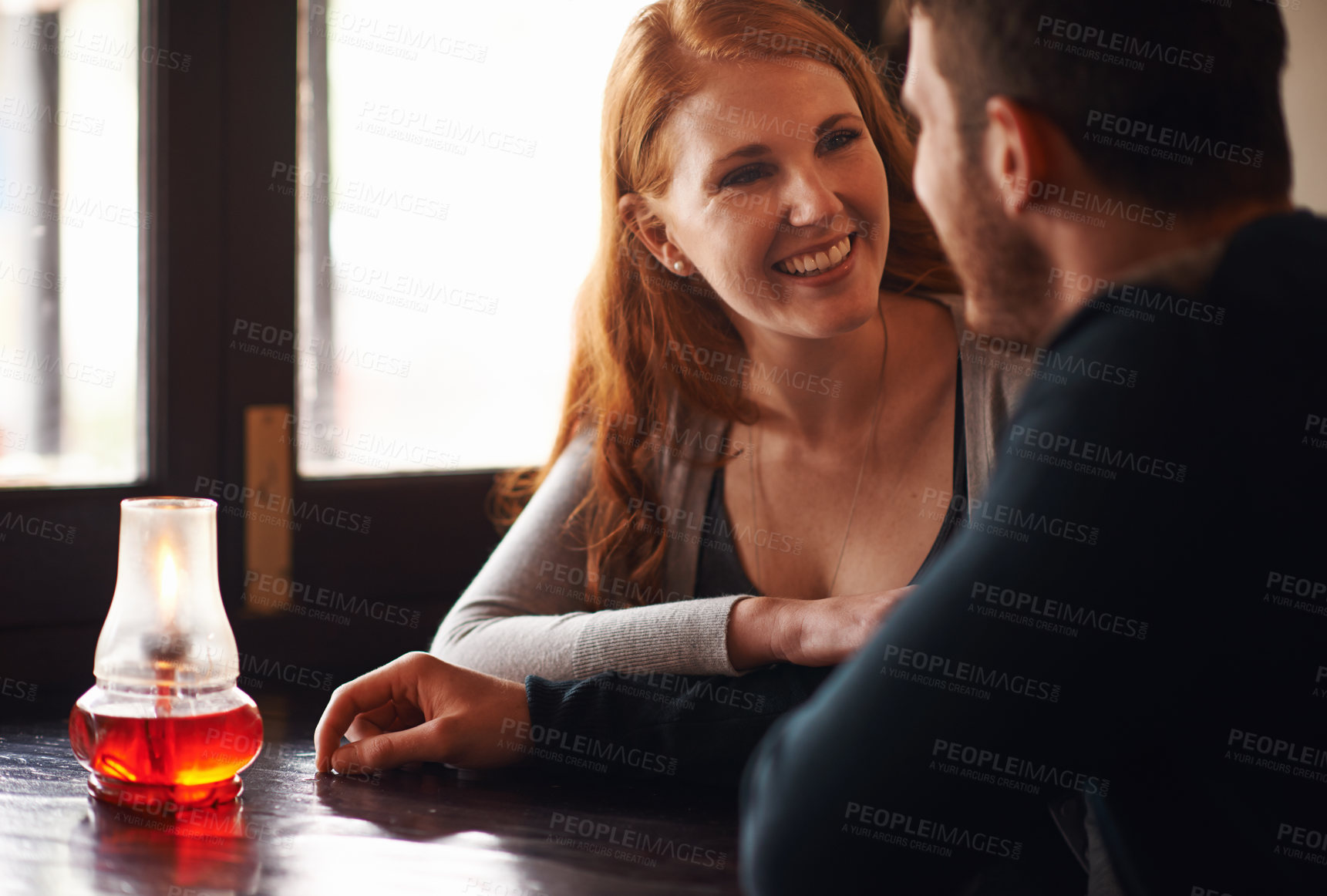Buy stock photo A cropped shot of a young affectionate couple at a coffee shop