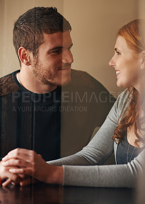 Buy stock photo Happy couple, holding hands and bonding with care, support or trust on date at indoor restaurant. Young man and woman with smile in happiness for social, conversation or friendly discussion at cafe