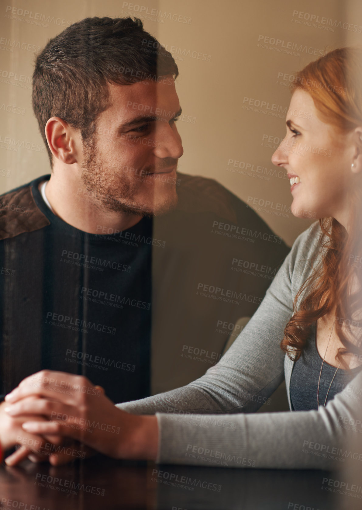 Buy stock photo Happy couple, holding hands and bonding with care, support or trust on date at indoor restaurant. Young man and woman with smile in happiness for social, conversation or friendly discussion at cafe