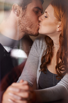 Buy stock photo Happy couple, kiss and love with intimacy for embrace, support or affection together at indoor cafe. Man and woman holding hands and bonding on date for relationship or anniversary at the coffee shop