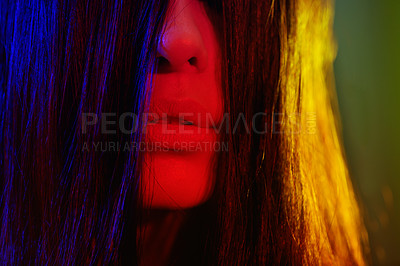 Buy stock photo Artistic shot of a young woman with her long hair covering part of her face
