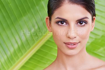 Buy stock photo Studio portrait of a beautiful young woman posing in front of a leaf