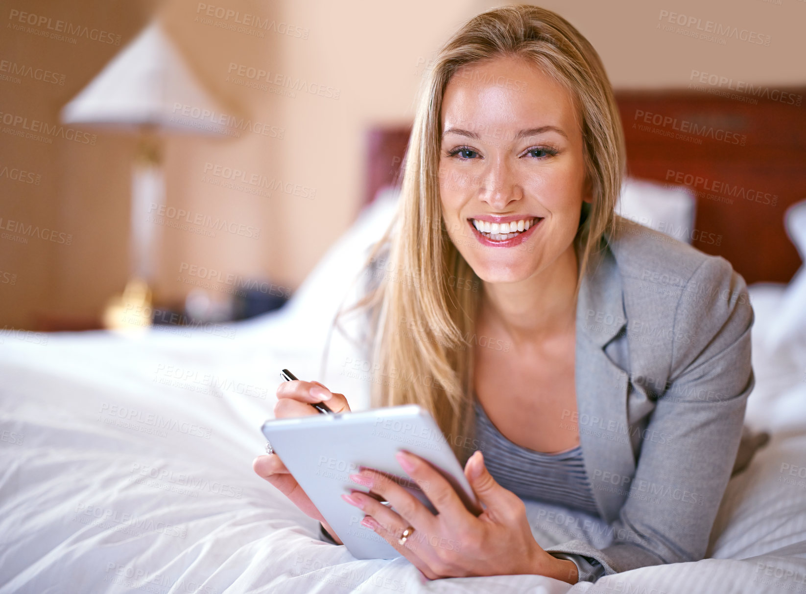 Buy stock photo A young businesswoman using a digital tablet in a bedroom