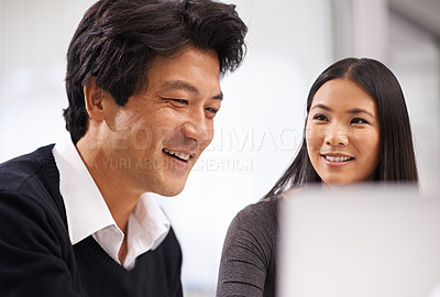 Buy stock photo Shot of two business colleagues working together at a laptop in the office