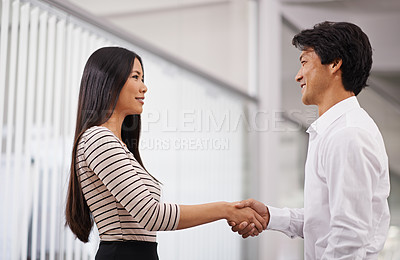 Buy stock photo Business people, handshake and meeting with agreement for deal or proposal together at the office. Young asian man and woman holding or shaking hands for b2b, greeting or partnership at the workplace