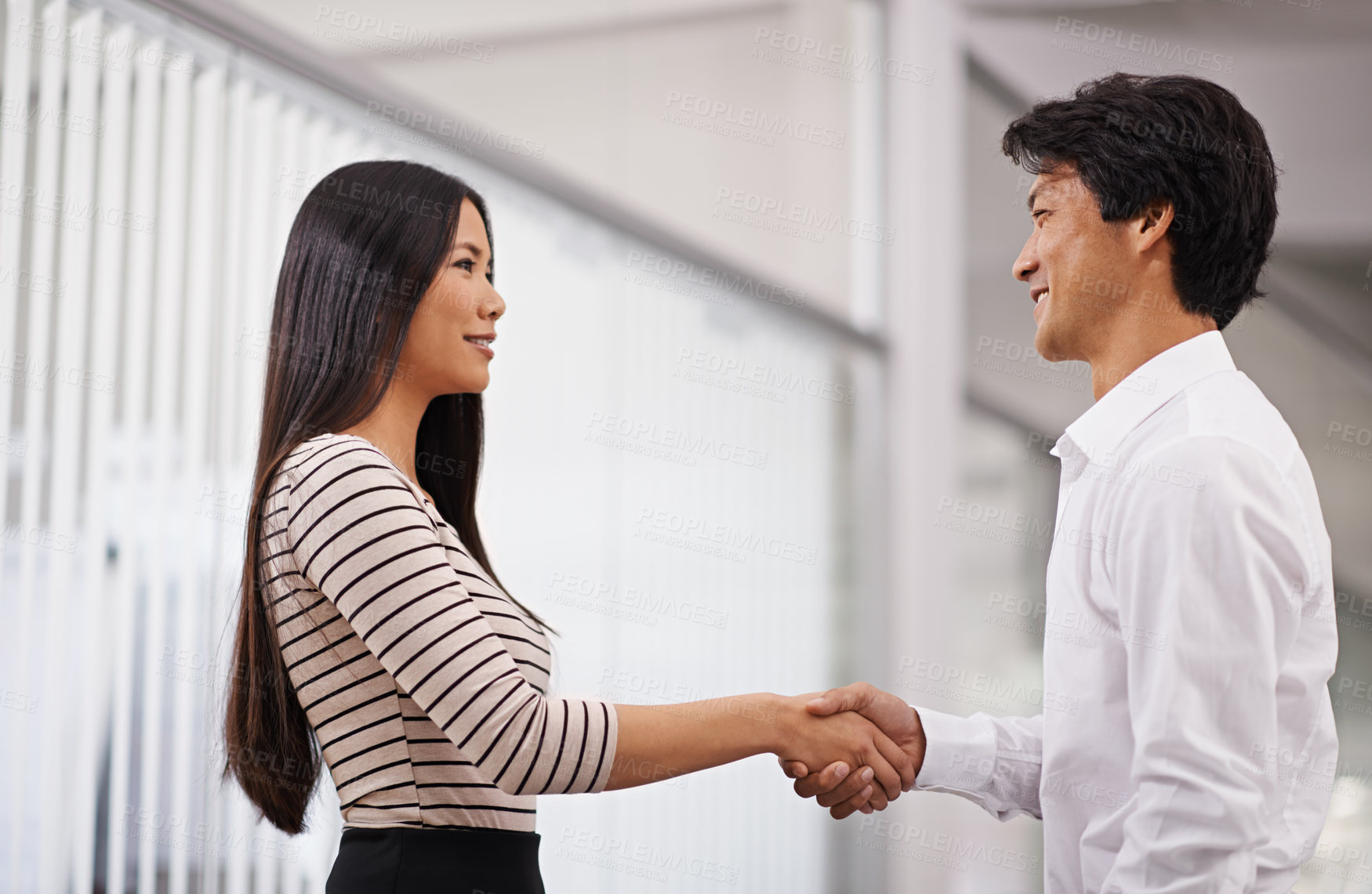 Buy stock photo Business people, handshake and meeting with agreement for deal or proposal together at the office. Young asian man and woman holding or shaking hands for b2b, greeting or partnership at the workplace