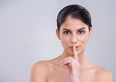 Buy stock photo Woman, finger to lips and secret for beauty with portrait, cosmetic care and wellness with silent gesture on grey background. Dermatology, skincare and whisper with emoji, selfcare and natural glow