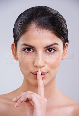 Buy stock photo Woman, finger on mouth and secret for beauty with portrait, cosmetic care and wellness with silent gesture on grey background. Dermatology, skincare and whisper with emoji, self care and natural glow