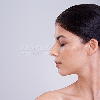 Buy stock photo Calm woman, face and profile with cosmetics, facial treatment or skincare on a gray studio background. Young female person, brunette or model with smile in satisfaction for beauty or makeup on mockup