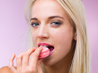Buy stock photo Cropped shot of a woman eating a macaroon