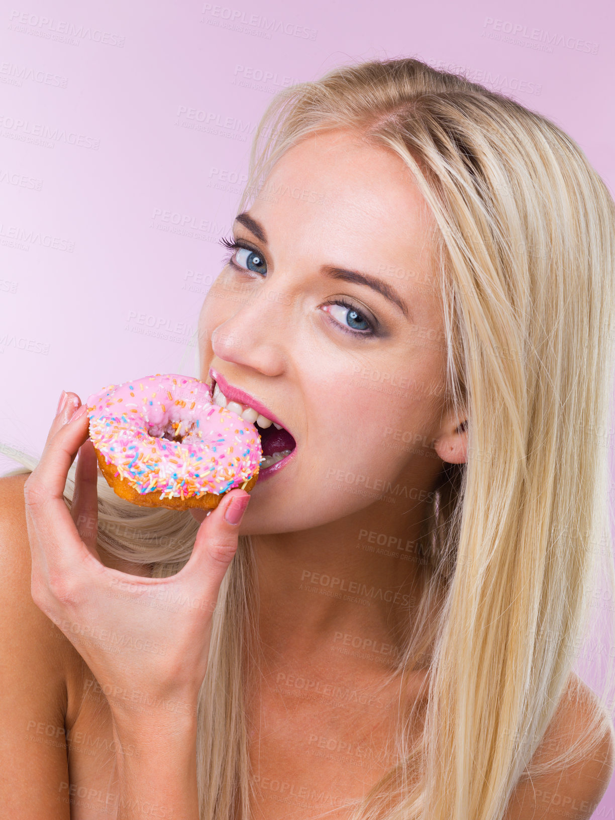 Buy stock photo Cropped shot of a woman eating a donut while isolated on pink