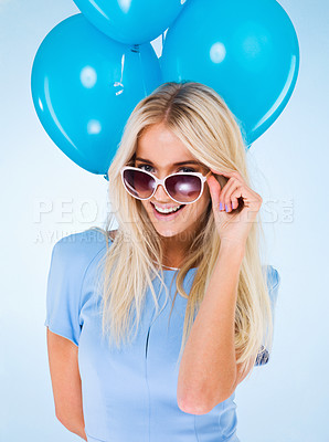 Buy stock photo A beautiful young woman in sunglasses posing with balloons