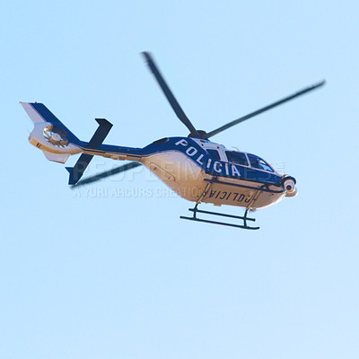 Buy stock photo Low angle shot of a police helicopter in the sky