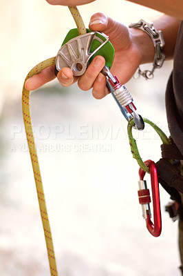 Buy stock photo Cropped shot of a young rock climber standing and adjusting his harnesses