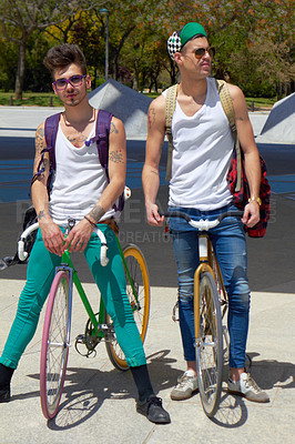 Buy stock photo Full length shot of two young guys sitting on their bikes outdoors