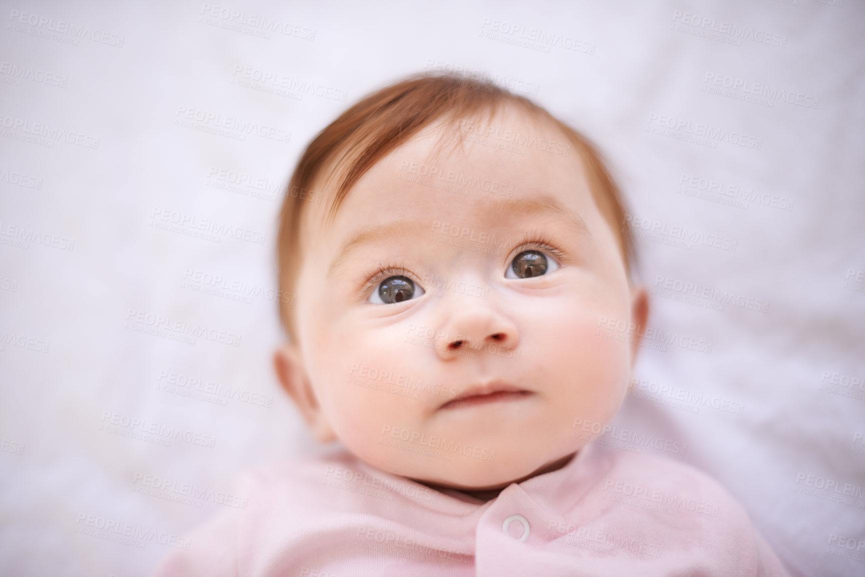 Buy stock photo Baby, bed and girl in nursery with curiosity for childhood development, growth and relax in house. Newborn, ginger and kid with wonder for knowledge, wellness and calm child at home from above