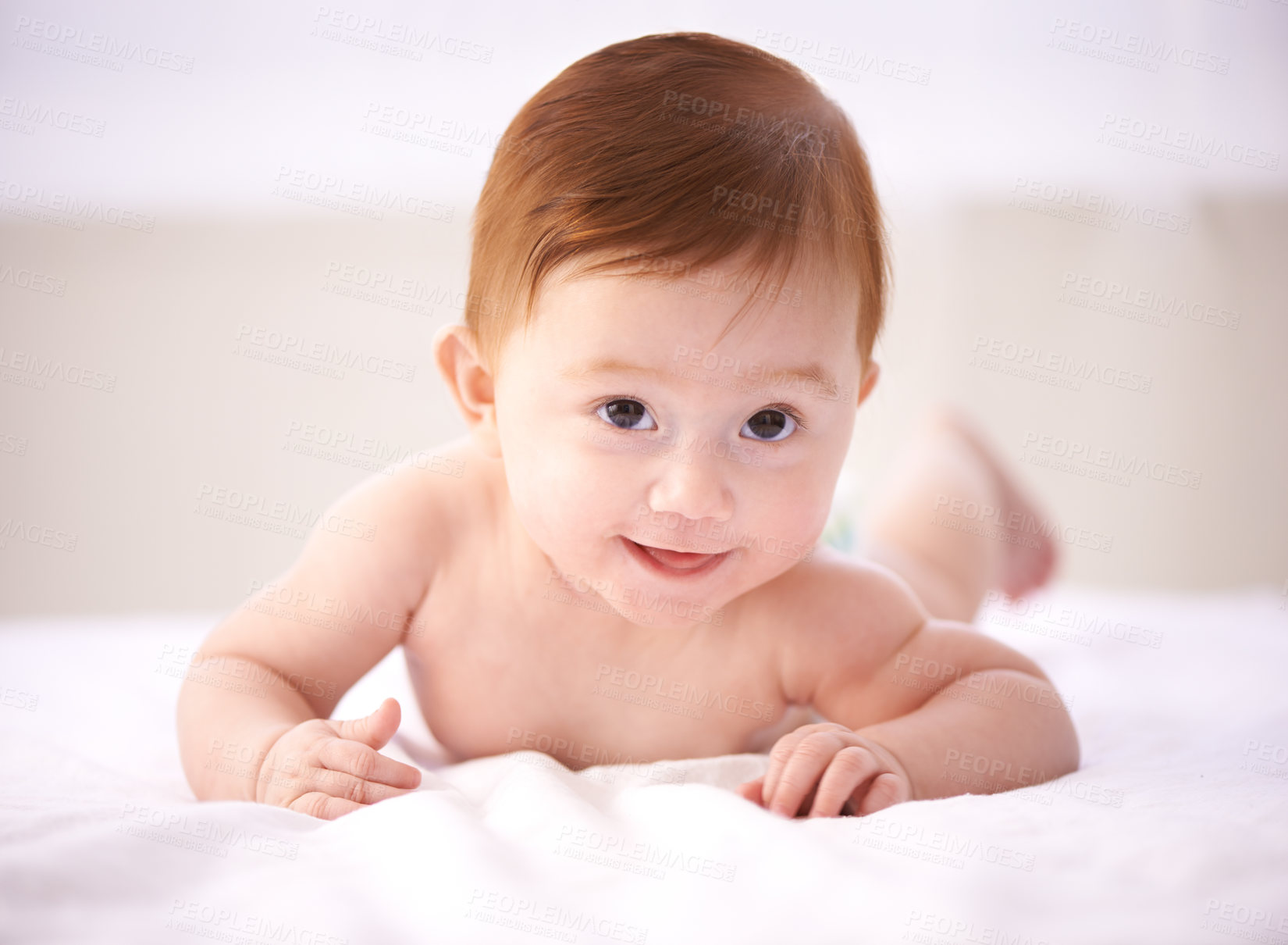 Buy stock photo Portrait, bed and happy baby with smile, relax and tummy time or child development in nursery comfort. Girl, infant or newborn wellness in family home for childcare, crawl or kid learning for growth