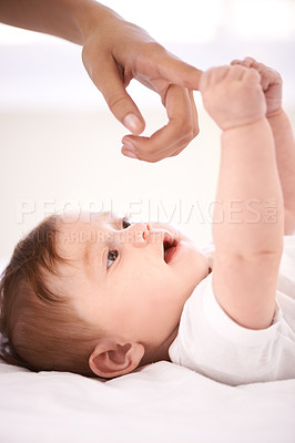 Buy stock photo Baby, bed and mom for holding finger with care, bonding and love with connection in family home. Infant, newborn and hands with touch, growth and childhood for development in nursery at apartment