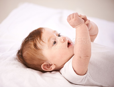 Buy stock photo A cropped shot of an adorable baby girl lying on a blanket