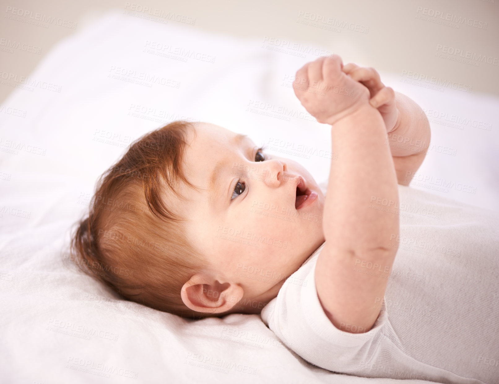 Buy stock photo A cropped shot of an adorable baby girl lying on a blanket